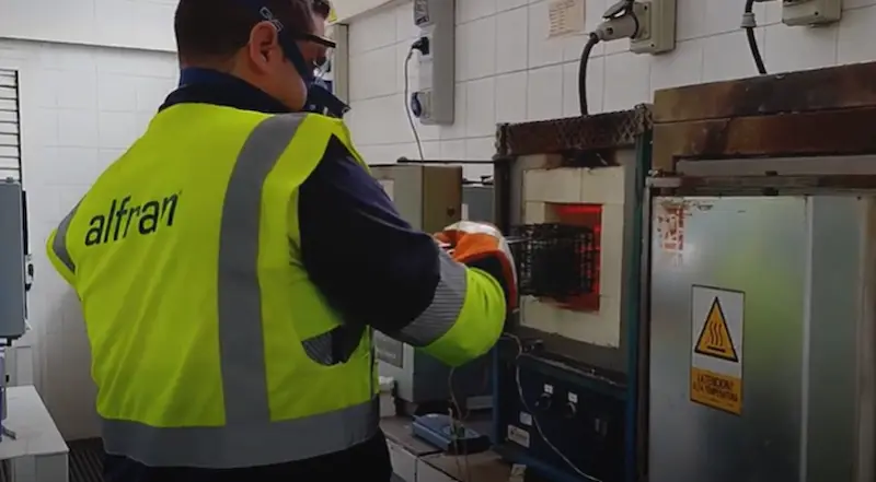 Técnico trabajando con horno de laboratorio para ensayo de materiales refractarios